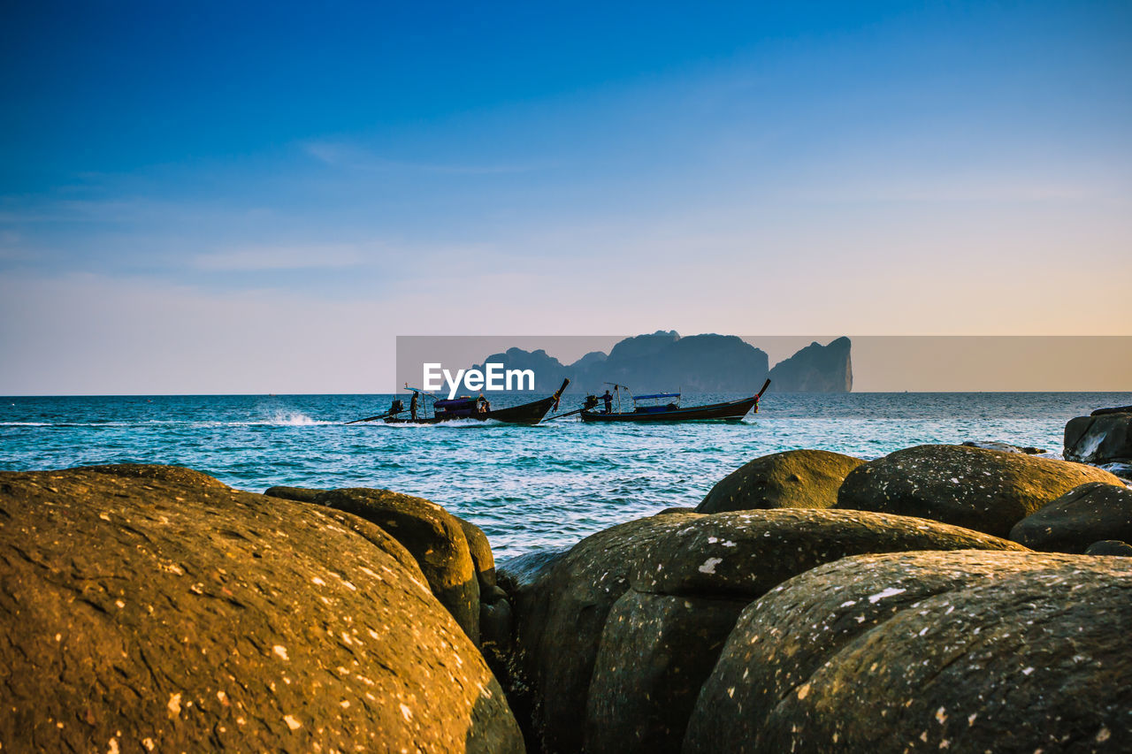 ROCKS ON BEACH AGAINST SKY