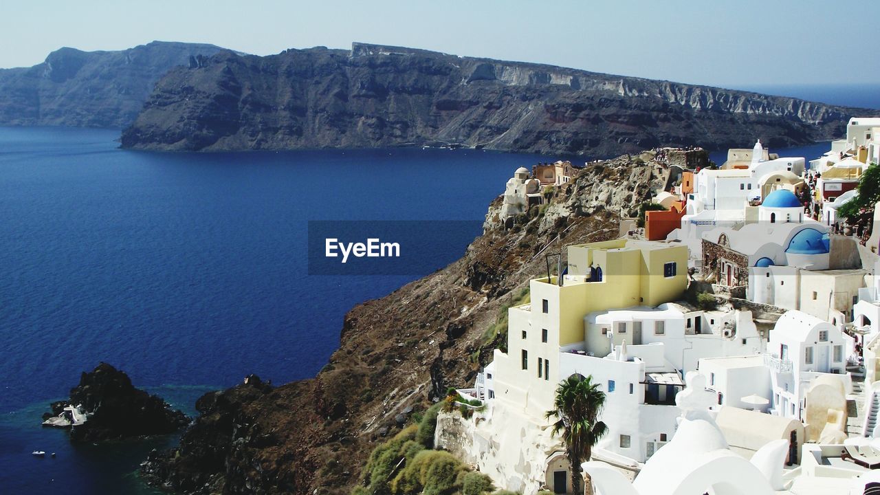 Town at santorini with rocky mountains at aegean sea