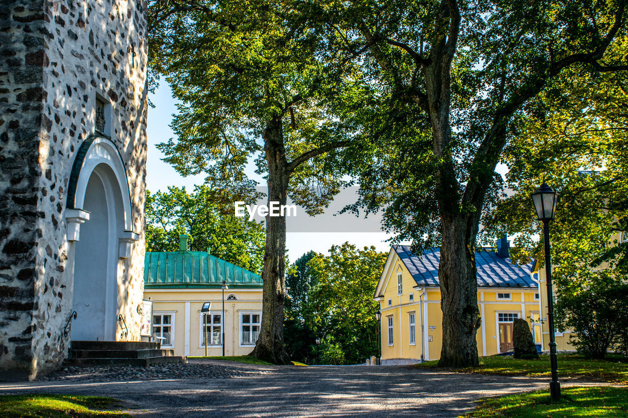 TREES AND HOUSES AGAINST BUILDING