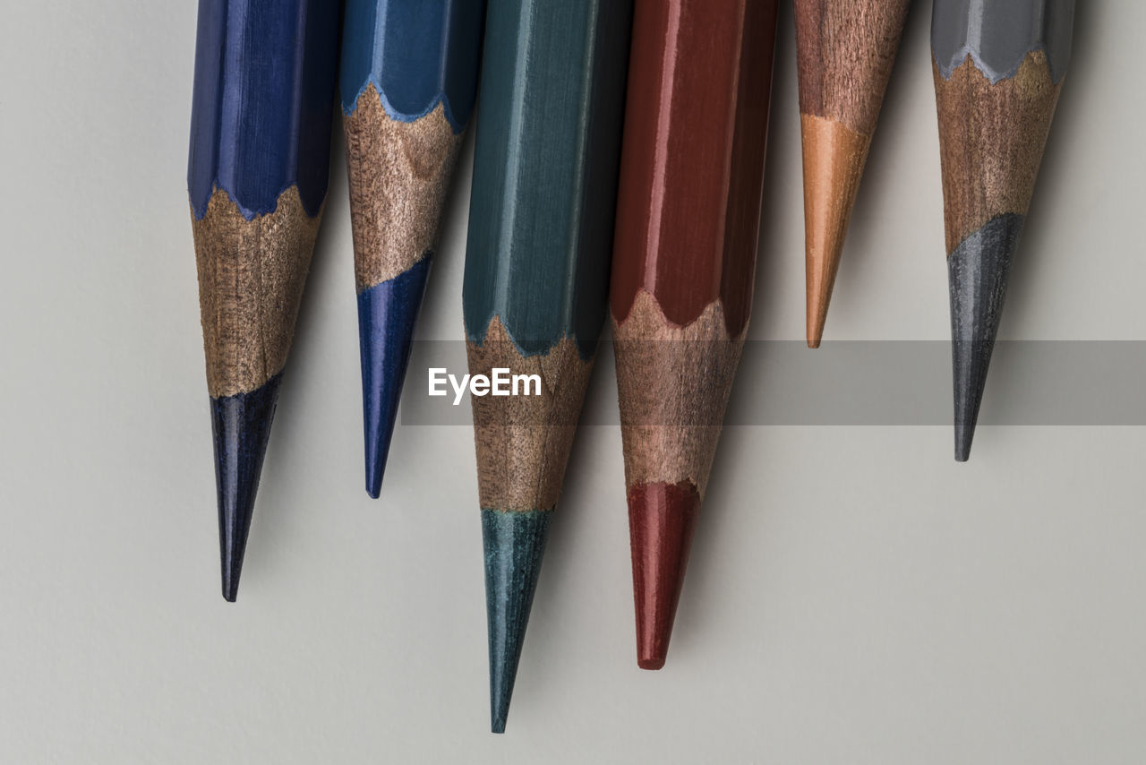 HIGH ANGLE VIEW OF MULTI COLORED PENCILS IN ROW