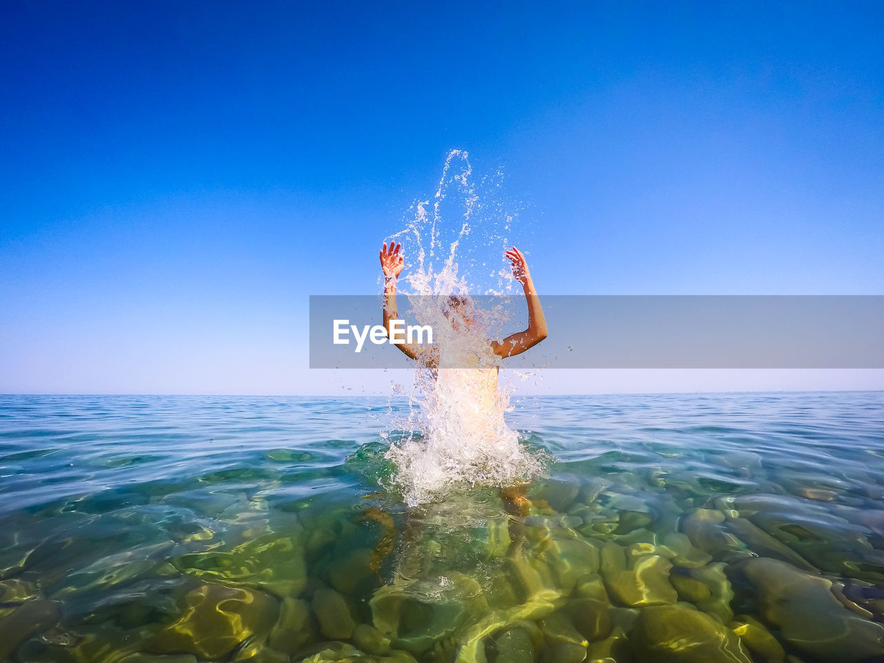 Man swimming in sea against clear sky