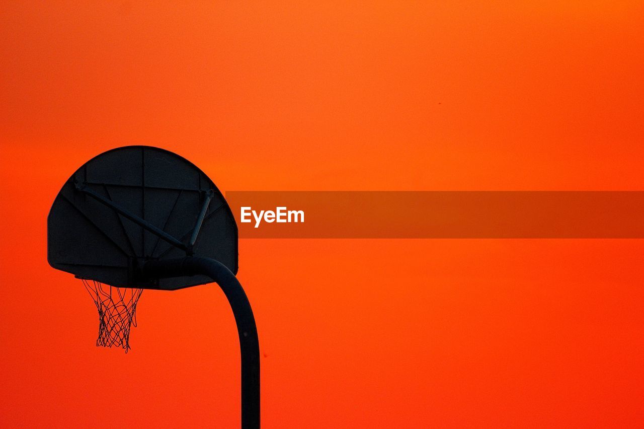 Low angle view of basketball hoop against clear sky during sunset
