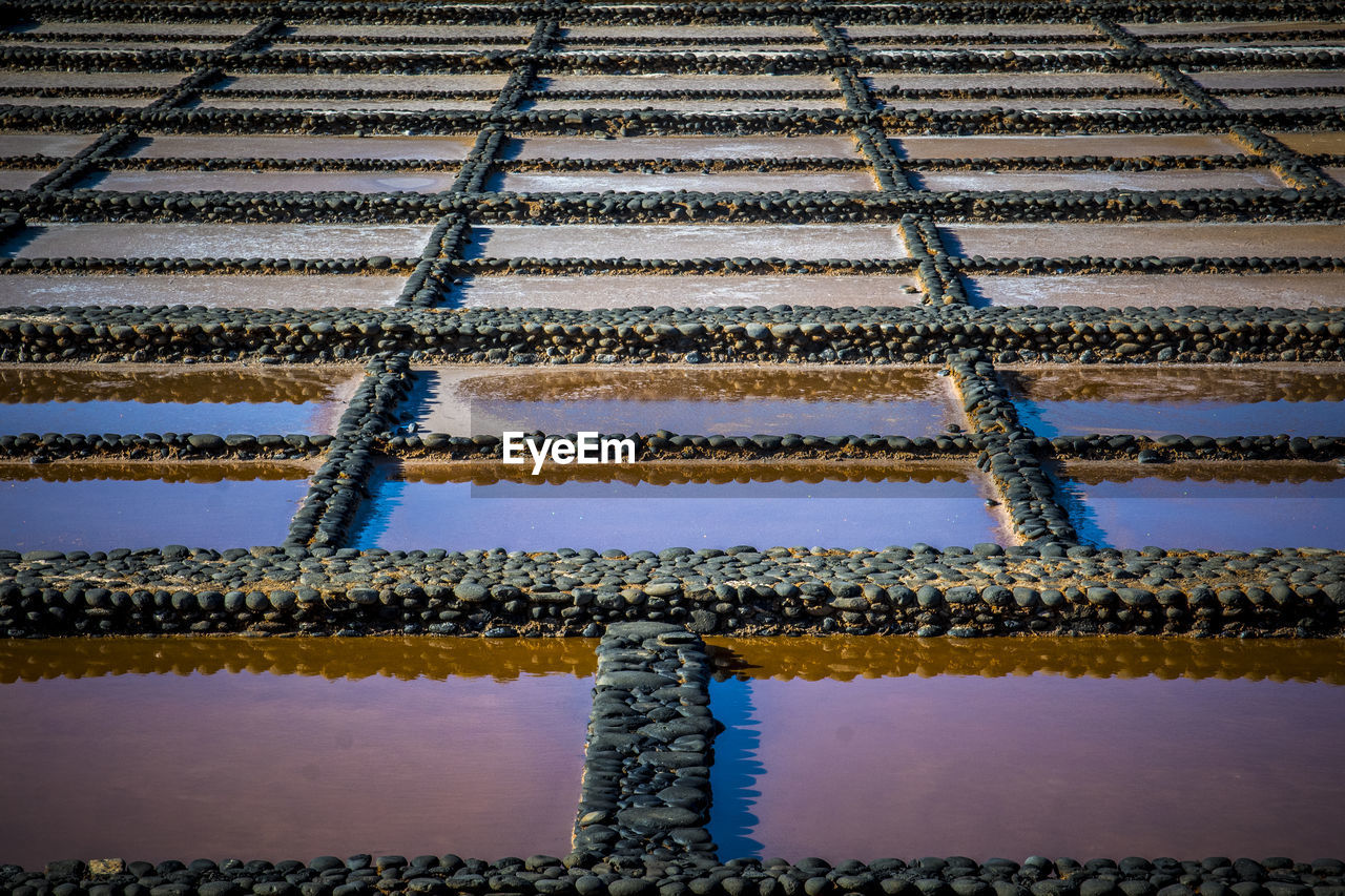View on traditional rectangular salt evaporation ponds or salt pans creating a grid 