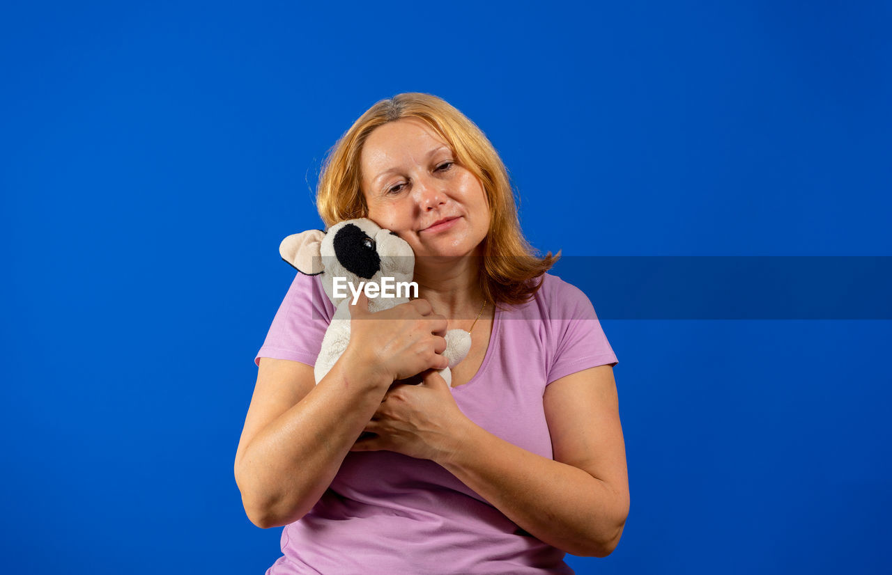 PORTRAIT OF WOMAN WEARING MASK AGAINST WHITE BACKGROUND