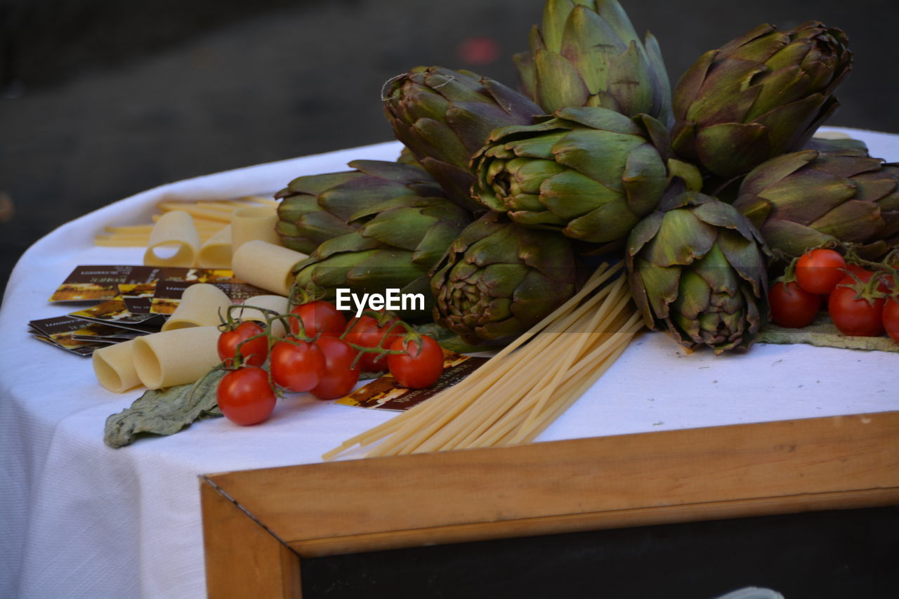 Artichokes and tomatoes on table