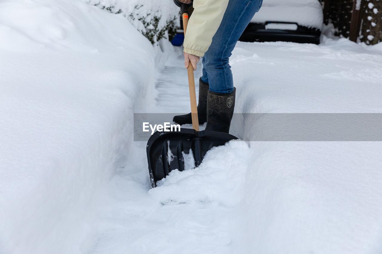 LOW SECTION OF PERSON ON SNOW COVERED MOUNTAIN