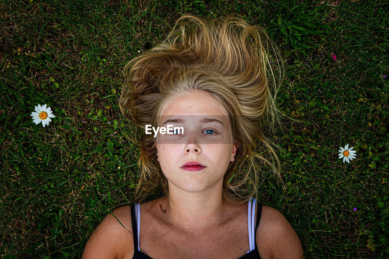 Portrait of teenage girl lying on grassy field