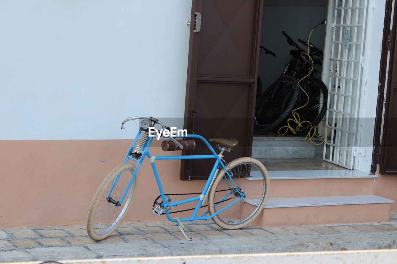 BICYCLE PARKED AGAINST WALL IN BUILDING