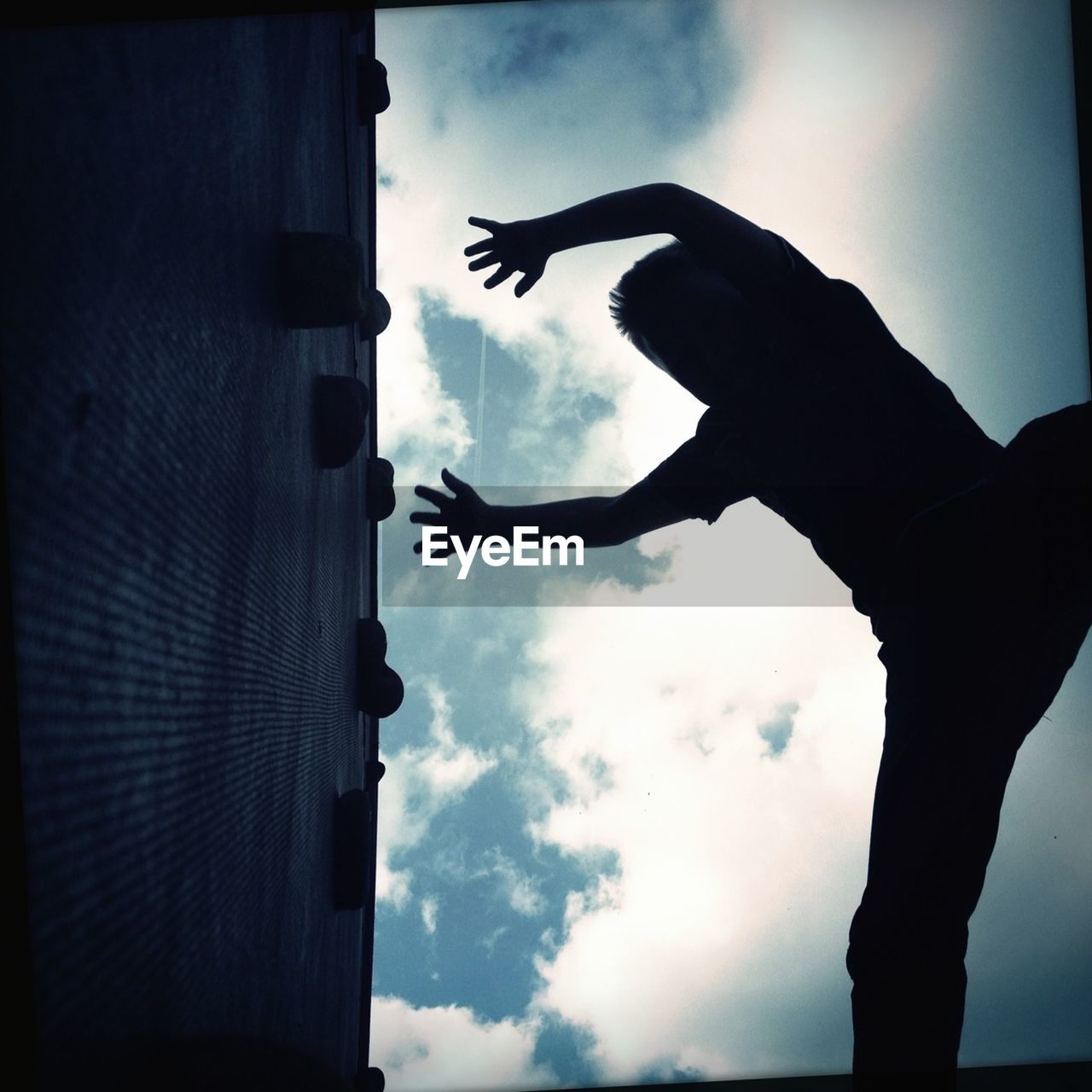 Low angle view of man reaching climbing wall