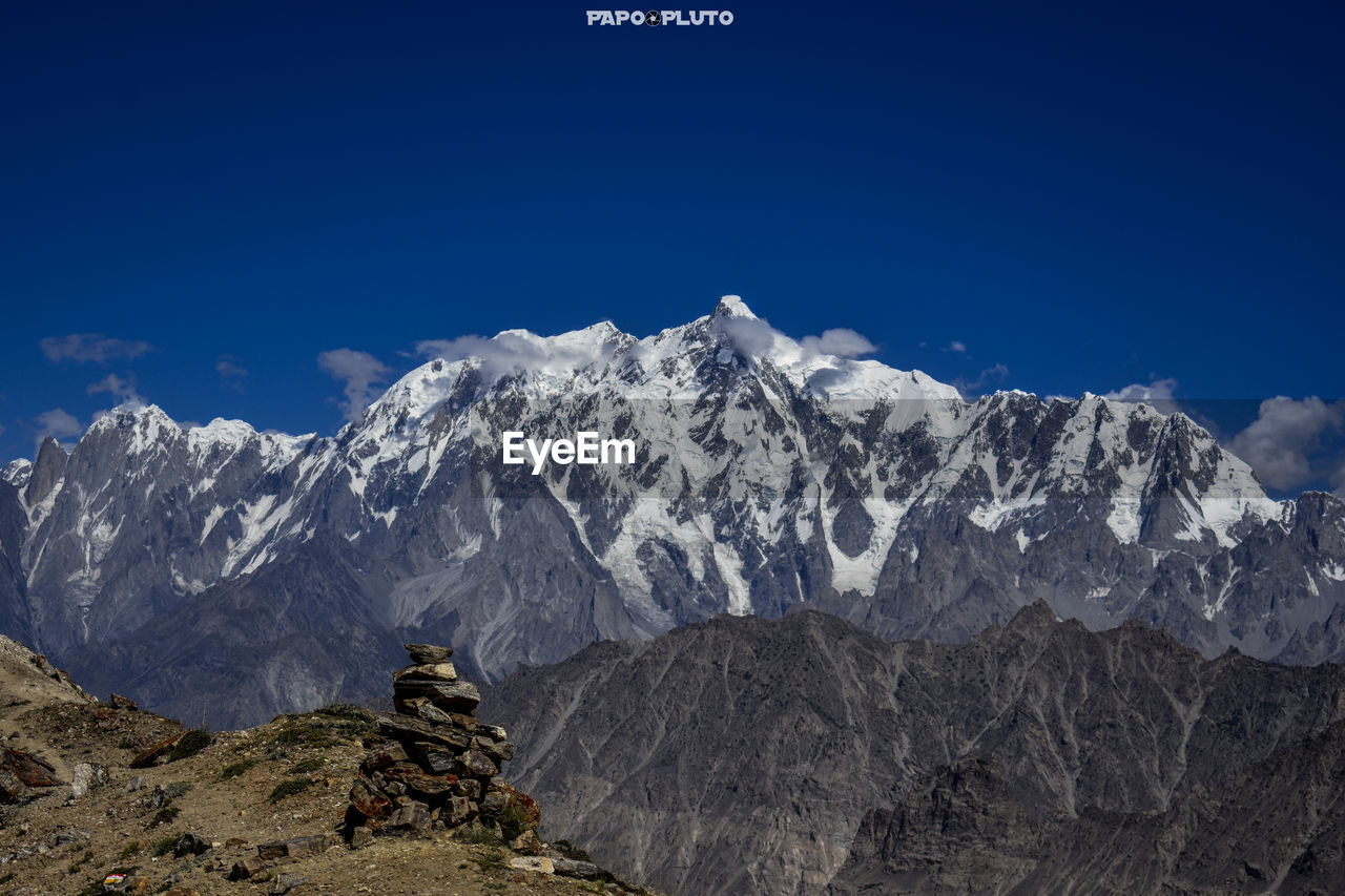 Scenic view of snowcapped mountains against blue sky