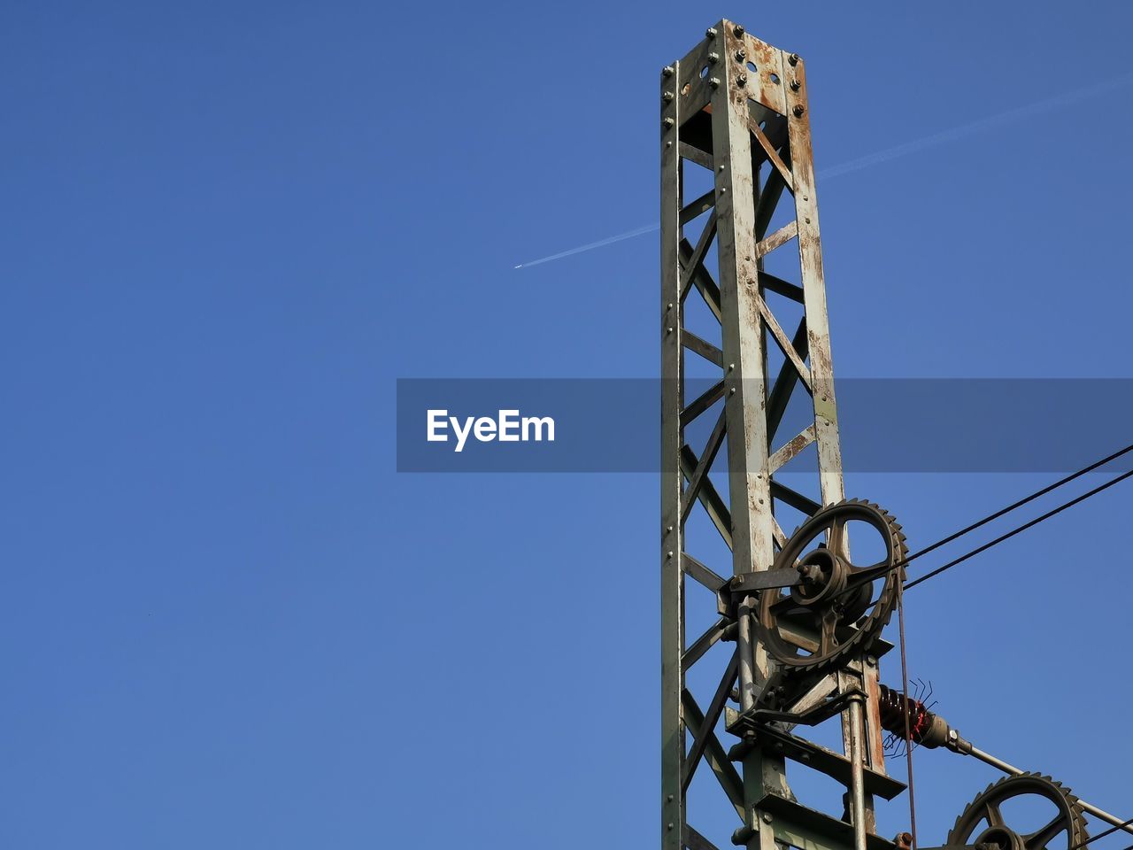 LOW ANGLE VIEW OF COMMUNICATIONS TOWER AGAINST CLEAR BLUE SKY