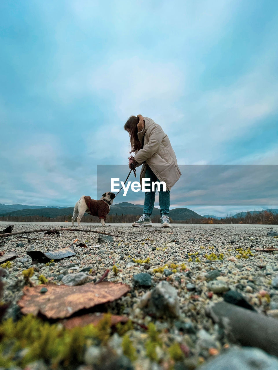 Woman with dog against sky