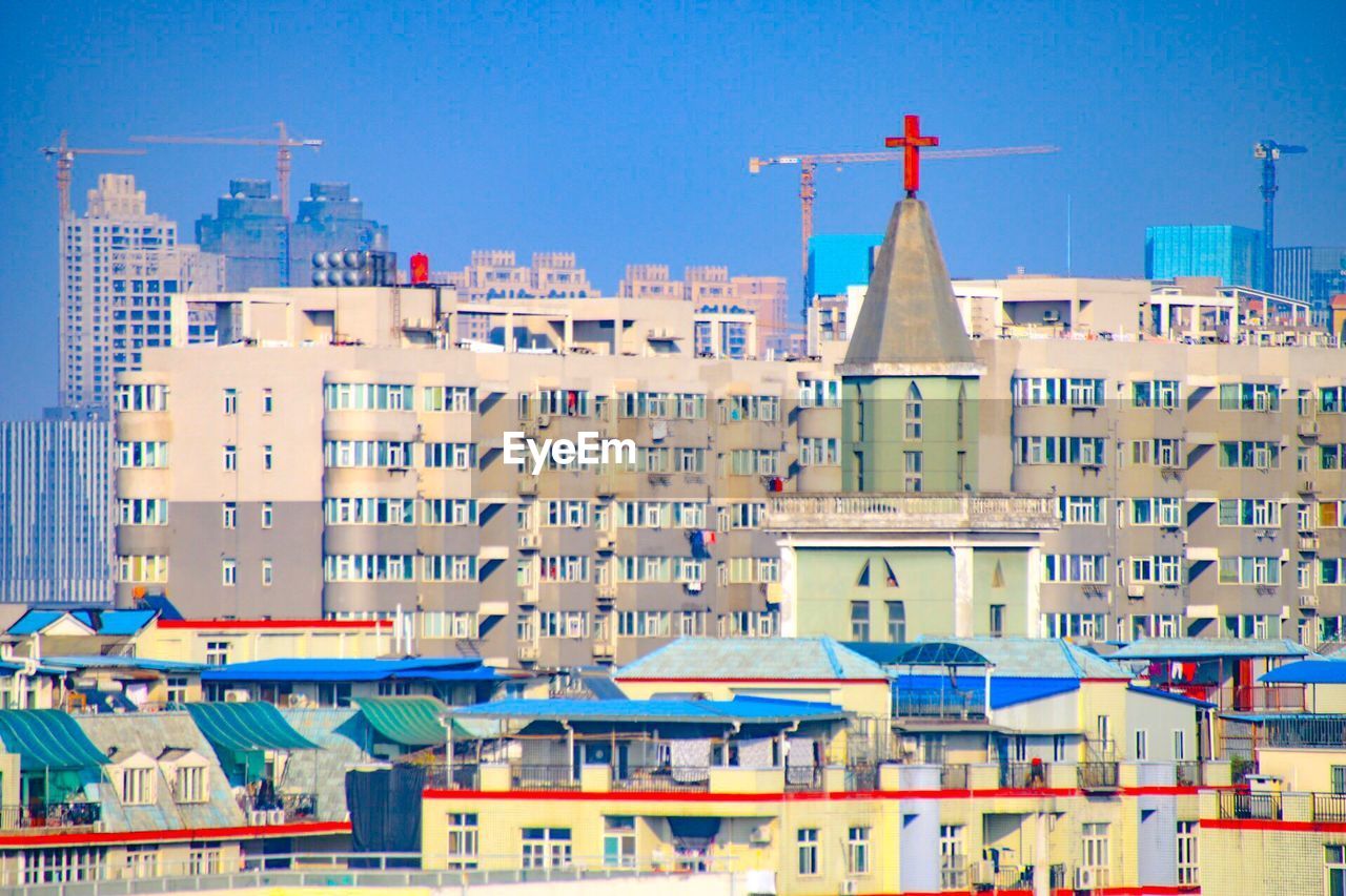 MULTI COLORED BUILDINGS IN CITY AGAINST CLEAR BLUE SKY