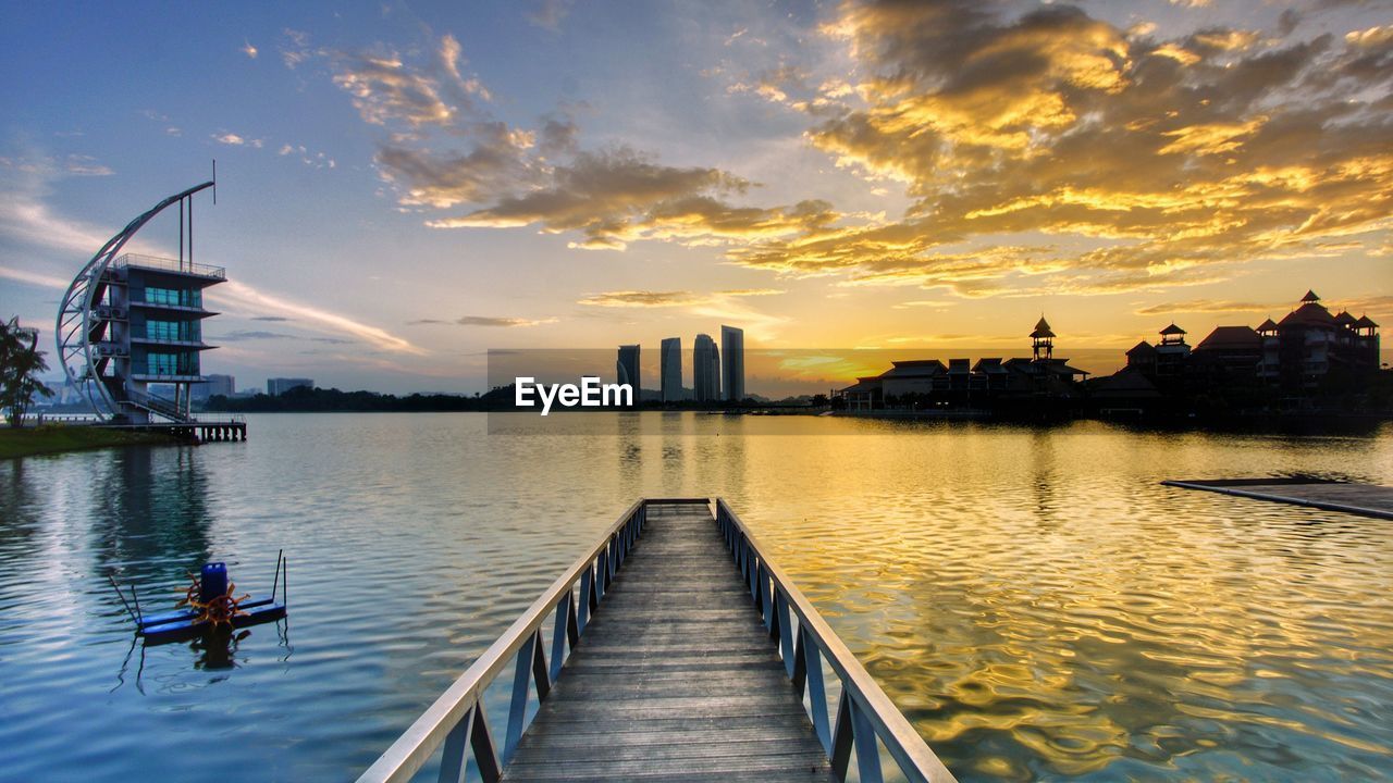 VIEW OF BRIDGE OVER RIVER AT SUNSET