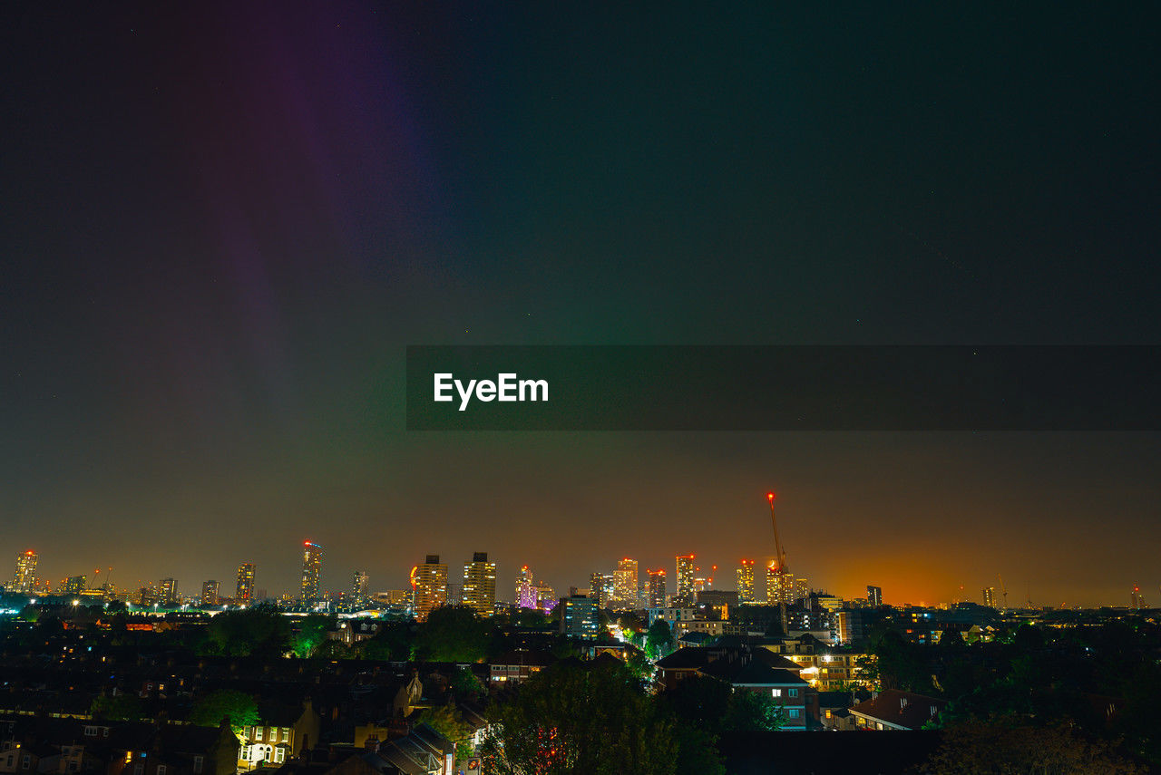 Illuminated cityscape against sky at night