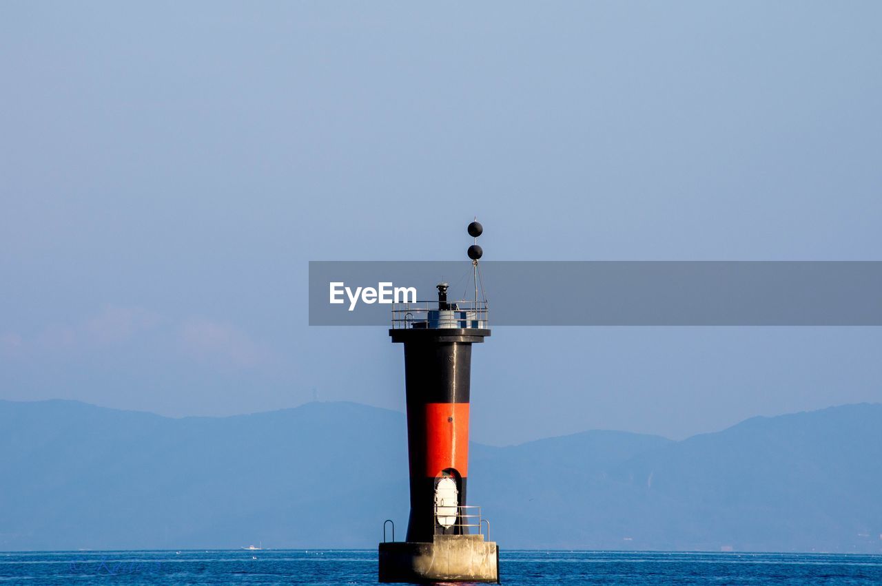 Beacon in sea against sky