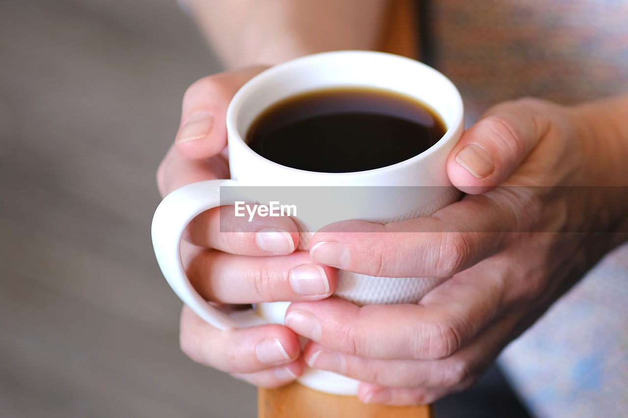 CROPPED IMAGE OF HAND HOLDING COFFEE WITH CUP