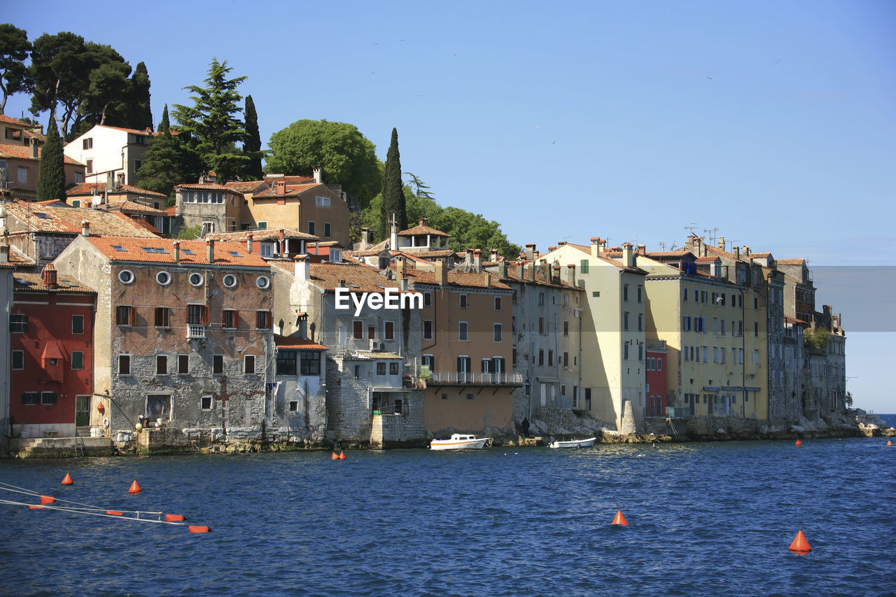 BUILDINGS BY SEA AGAINST CLEAR SKY