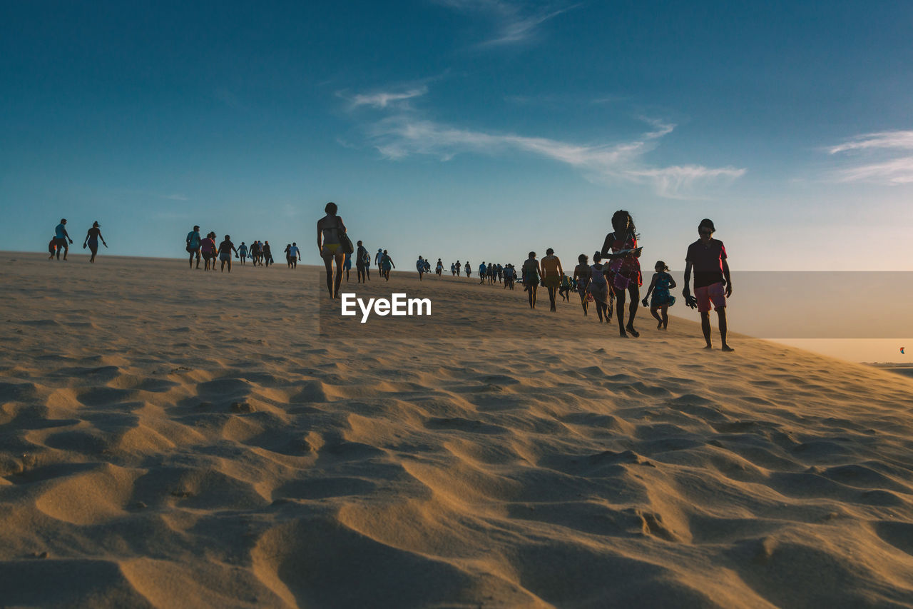 PEOPLE ON BEACH AGAINST SKY