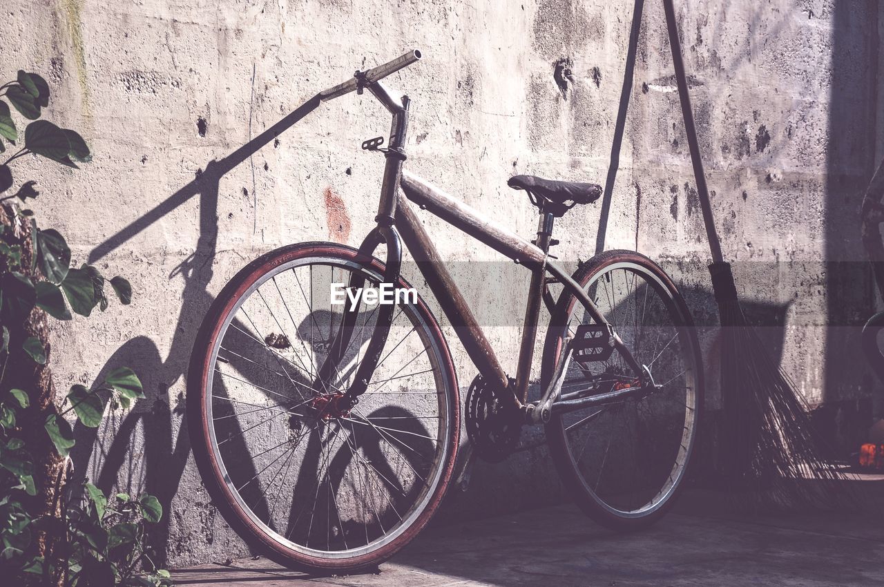 BICYCLES LEANING AGAINST WALL