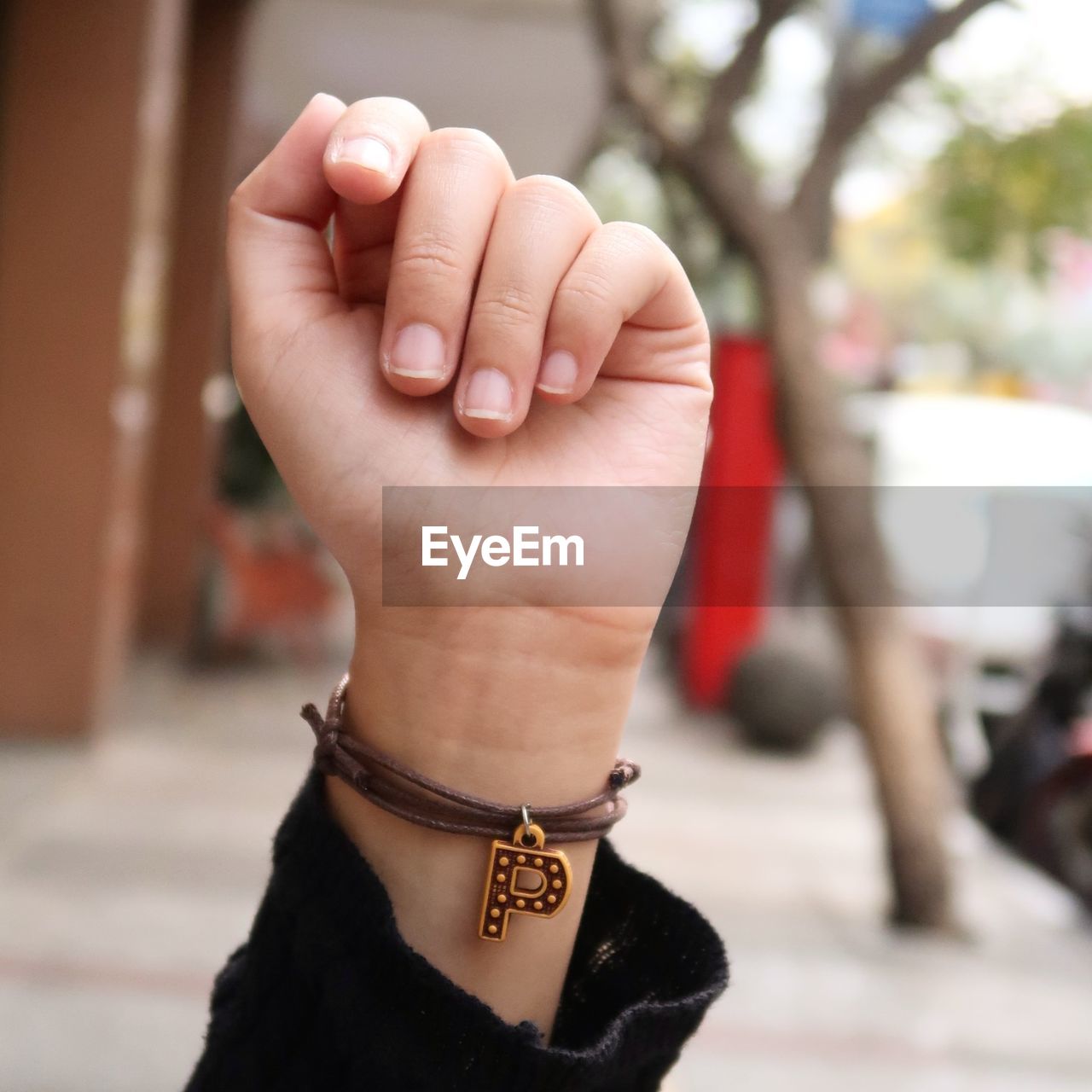 Cropped hand of woman wearing letter p bracelet