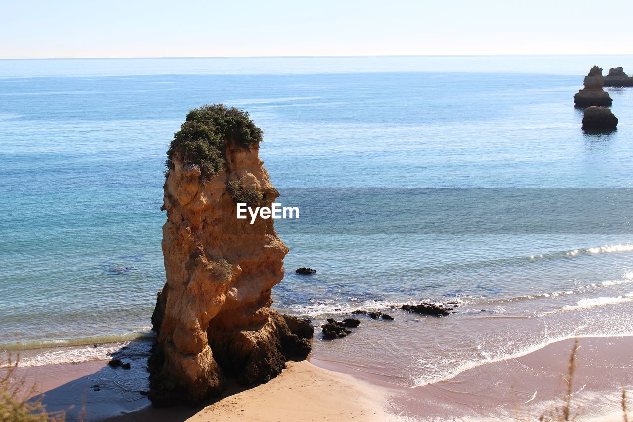 SCENIC VIEW OF ROCKS ON BEACH AGAINST SKY