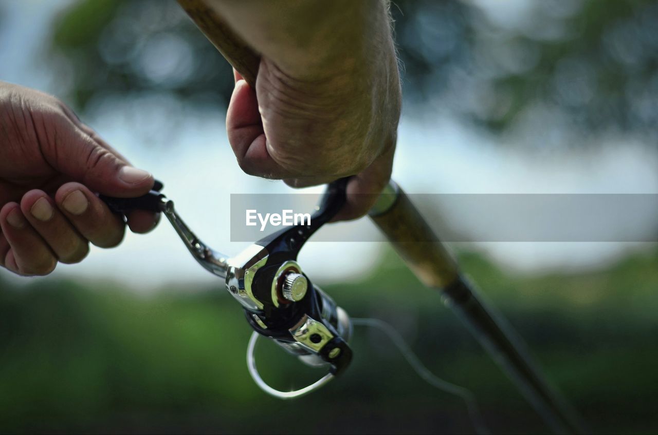 Hands preparing fishing rod