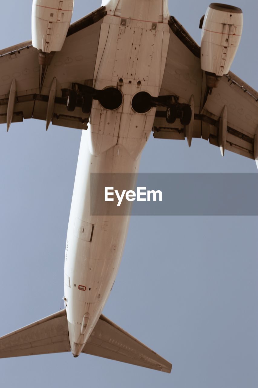 LOW ANGLE VIEW OF AIRPLANE FLYING AGAINST CLEAR SKY