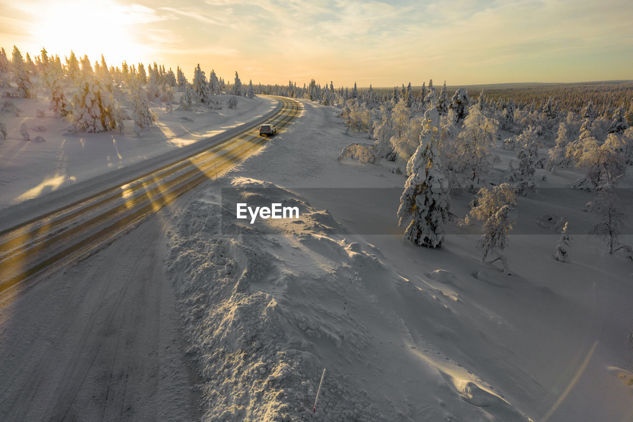 Last rays of sunlight reflecting on a road in finnish lapland