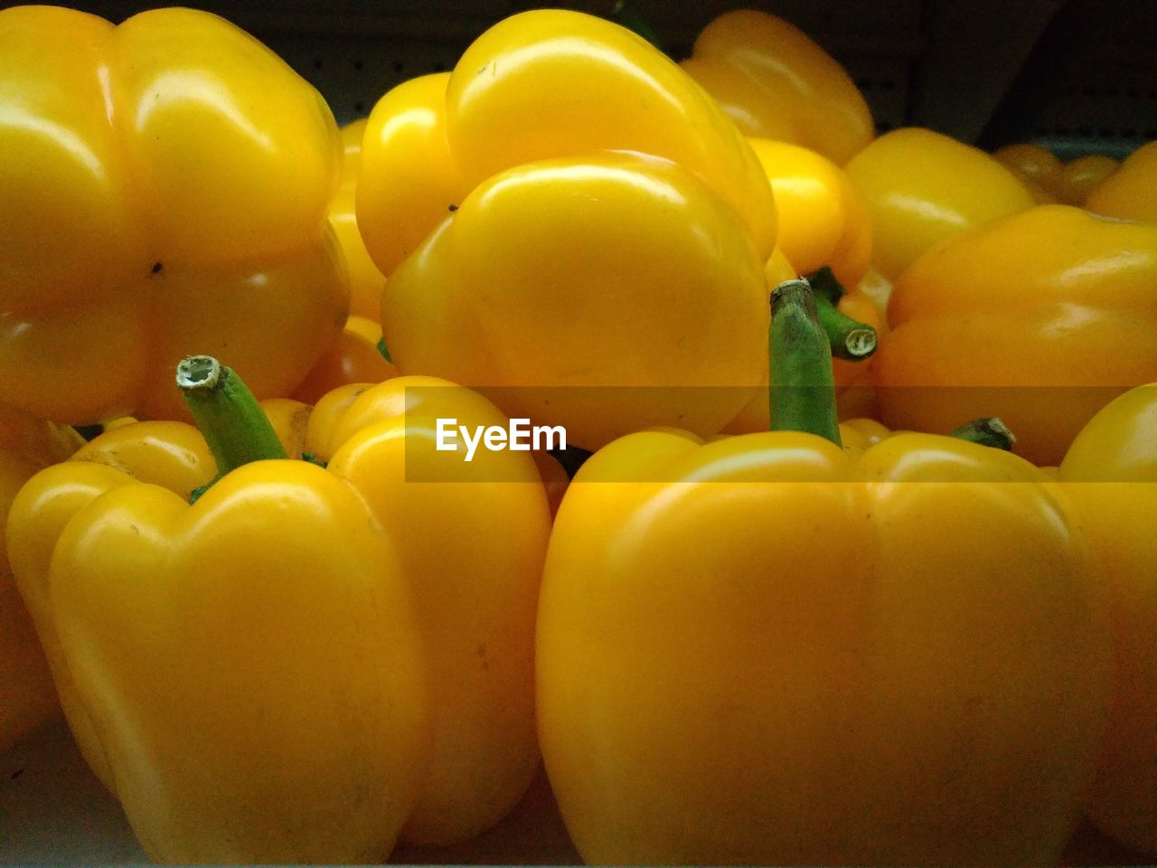 CLOSE-UP OF YELLOW BELL PEPPERS IN STACK OF