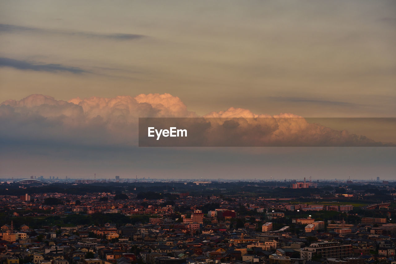 HIGH ANGLE VIEW OF ILLUMINATED CITY AGAINST SKY