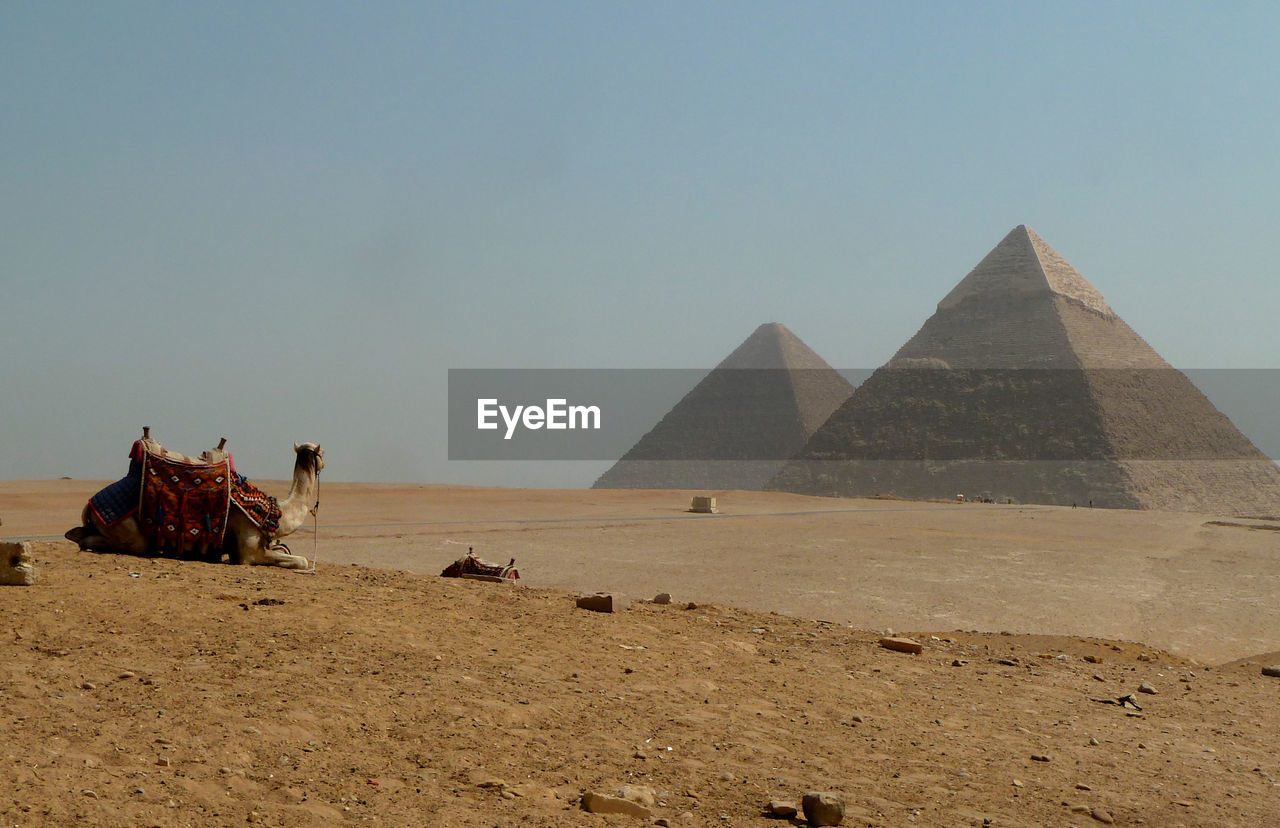 Giza pyramids on desert against clear sky