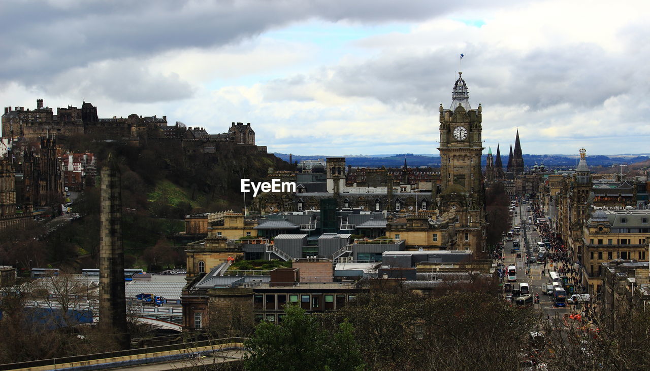 Buildings in city against cloudy sky