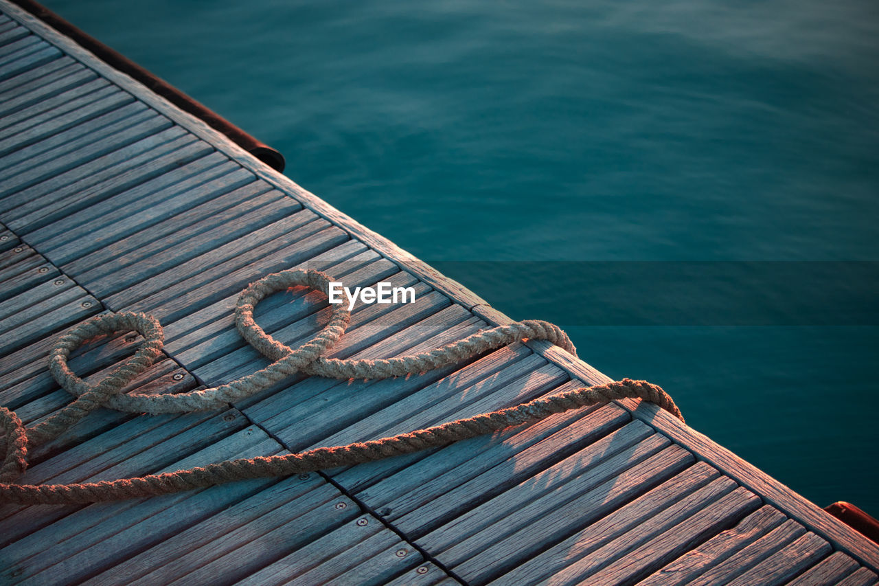 High angle view of rope on pier over sea during sunset