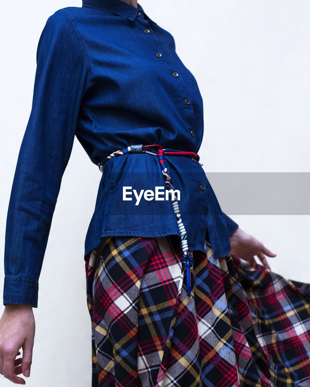 Midsection of woman in traditional clothing while standing against white background