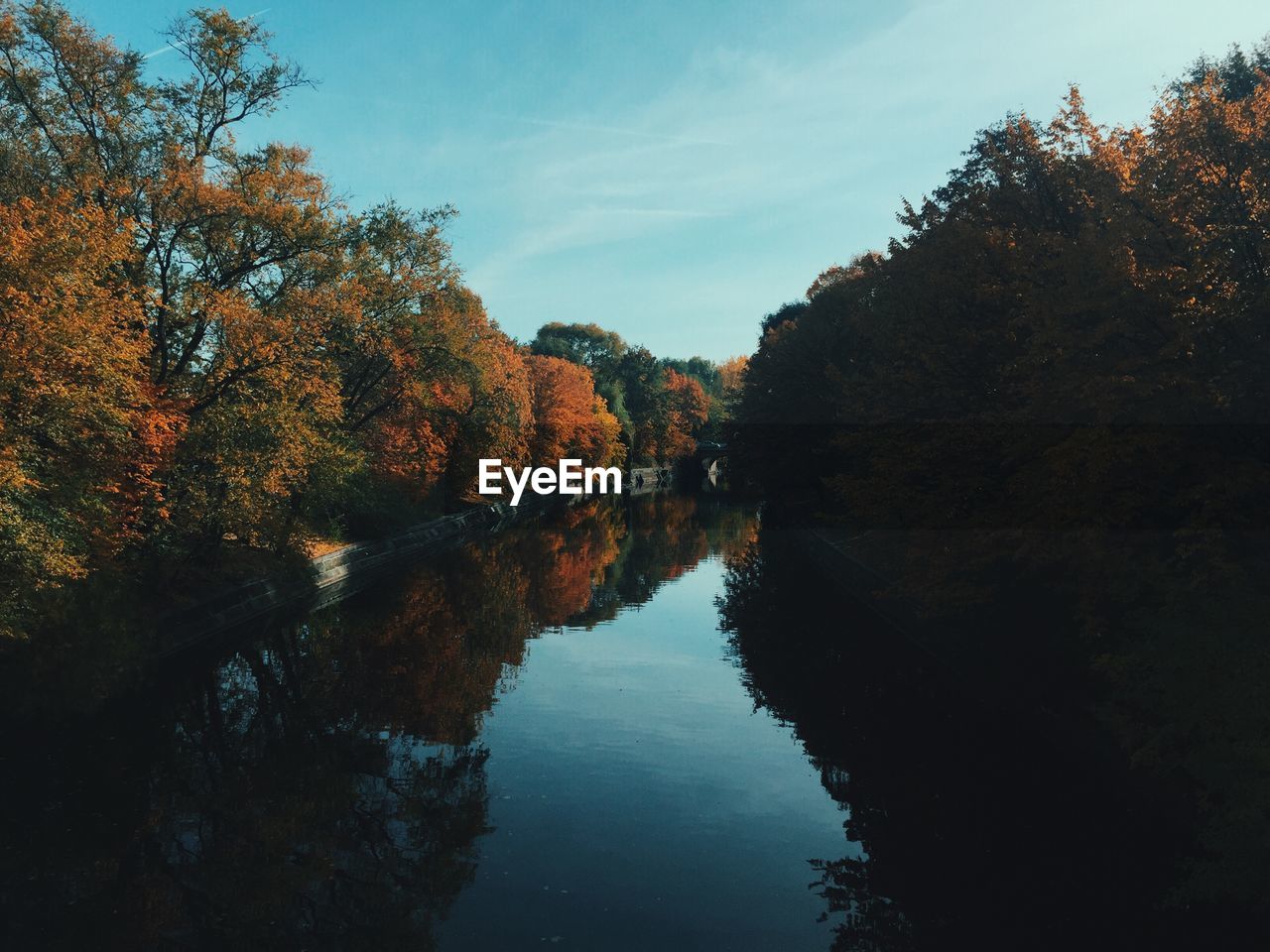 Scenic view of lake amidst autumn trees against sky