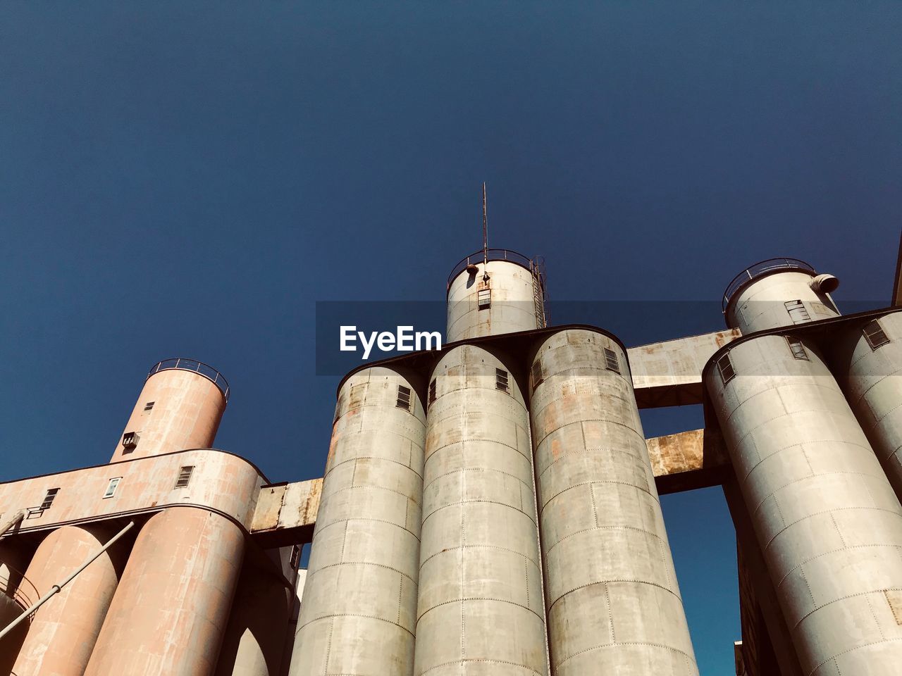 Low angle view of storage tanks against sky