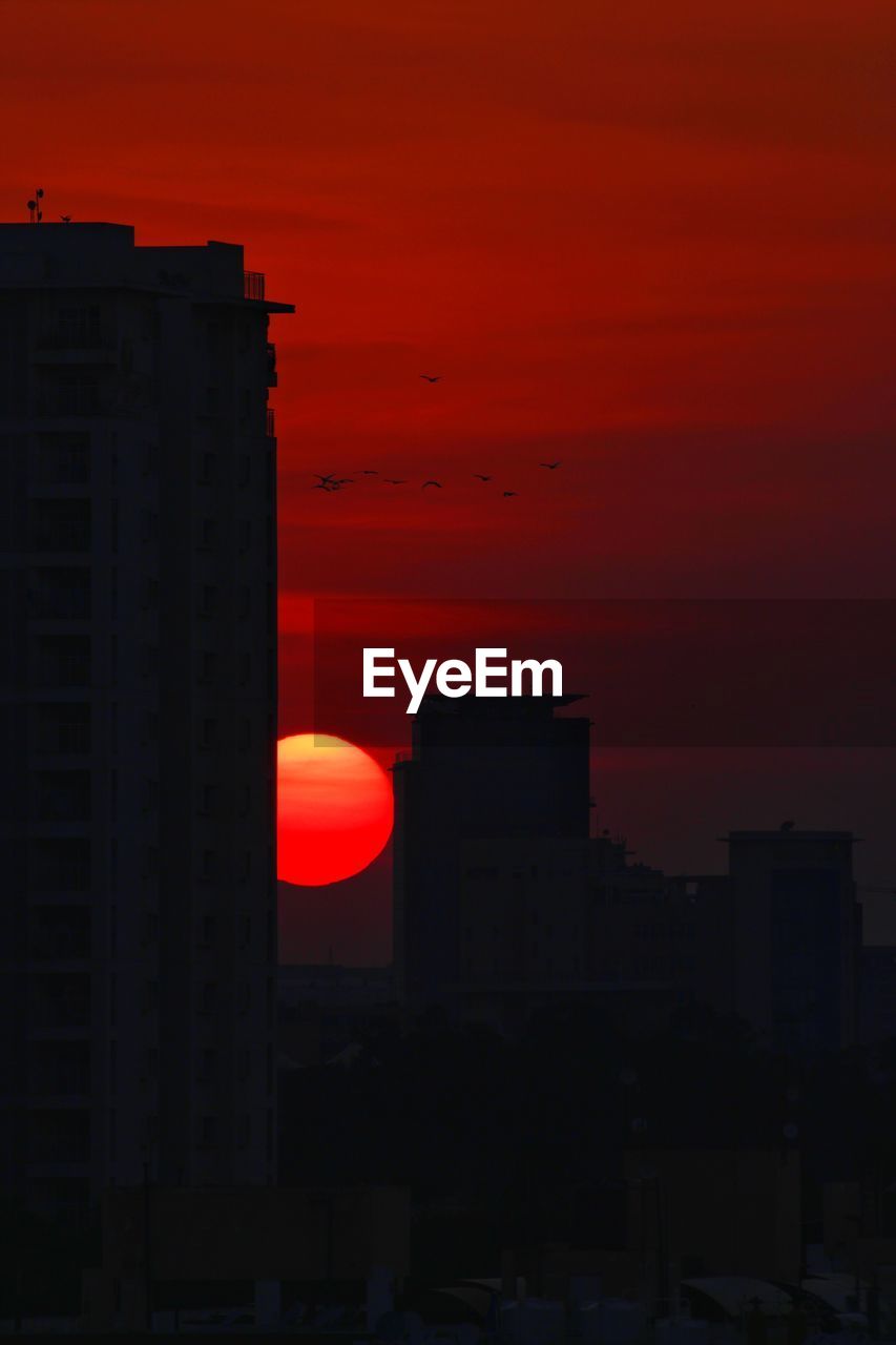 SILHOUETTE BUILDINGS AGAINST SKY AT SUNSET