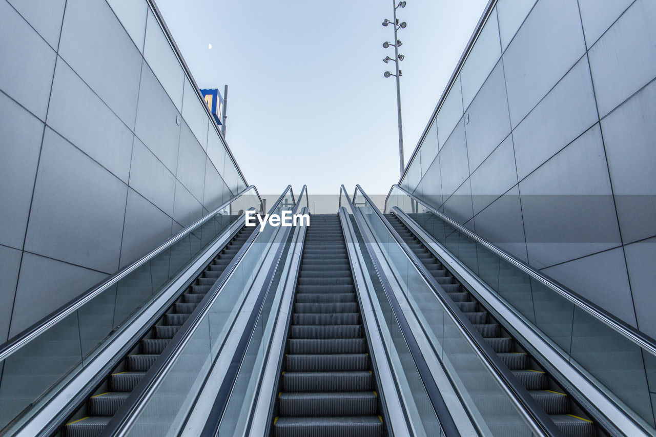 Low angle view of escalator against sky