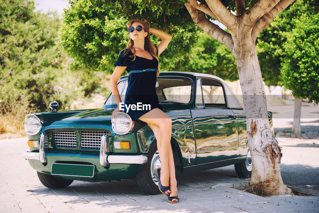 Woman posing by car