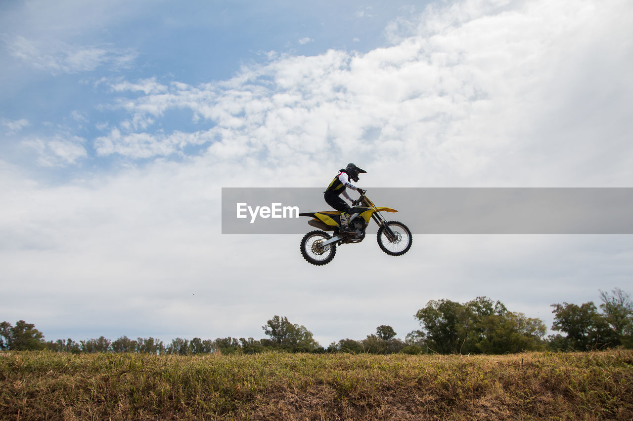 rear view of man riding bicycle on field