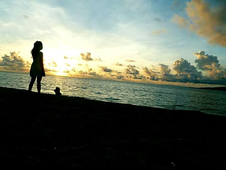 SILHOUETTE OF WOMAN STANDING ON BEACH