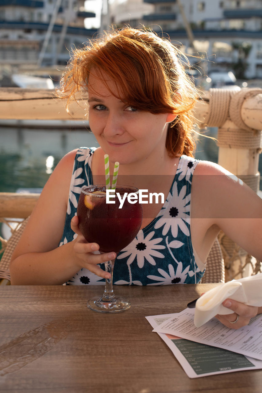 Portrait of woman drinking cocktail at restaurant