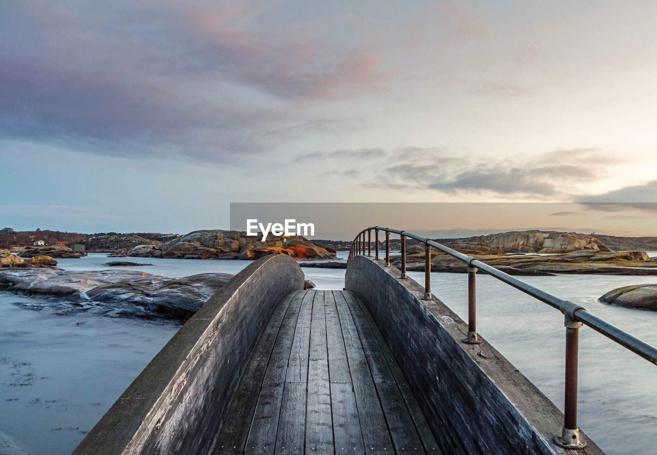 Scenic view of bridge over sea against sky during sunset