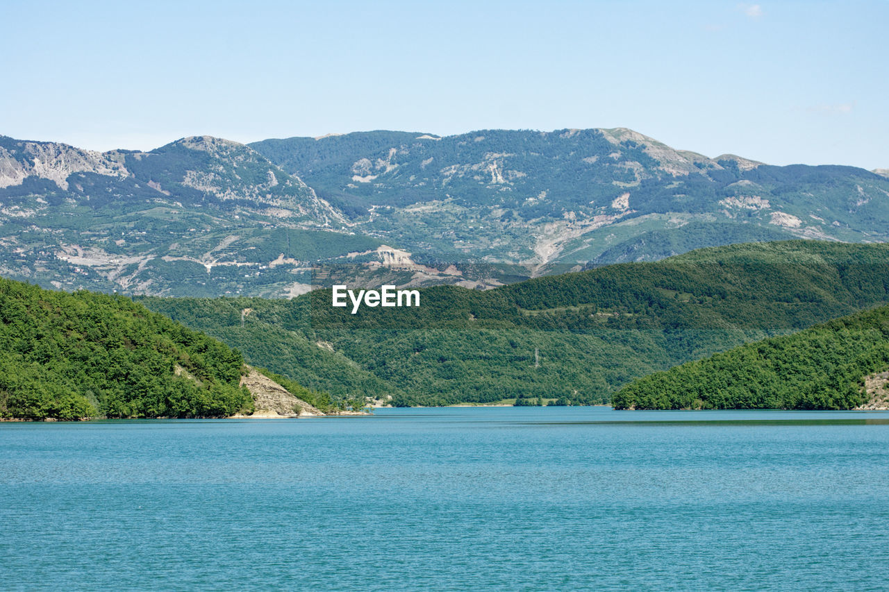 Scenic view of sea and mountains against sky