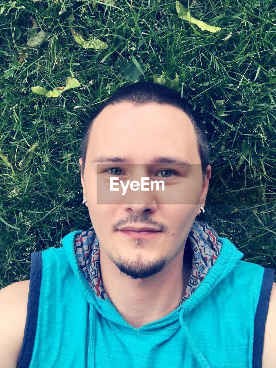 Overhead view of young man lying on grassy field