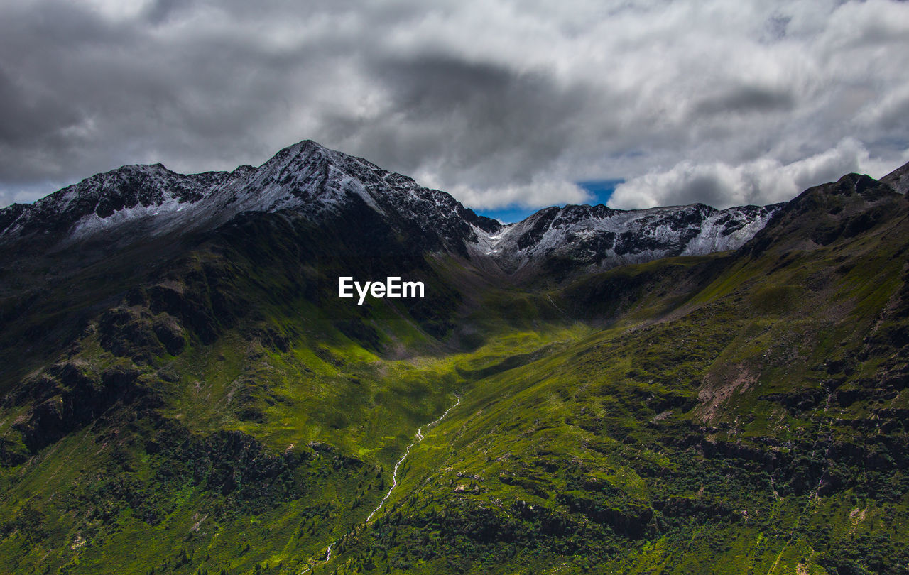 Scenic view of mountains against cloudy sky