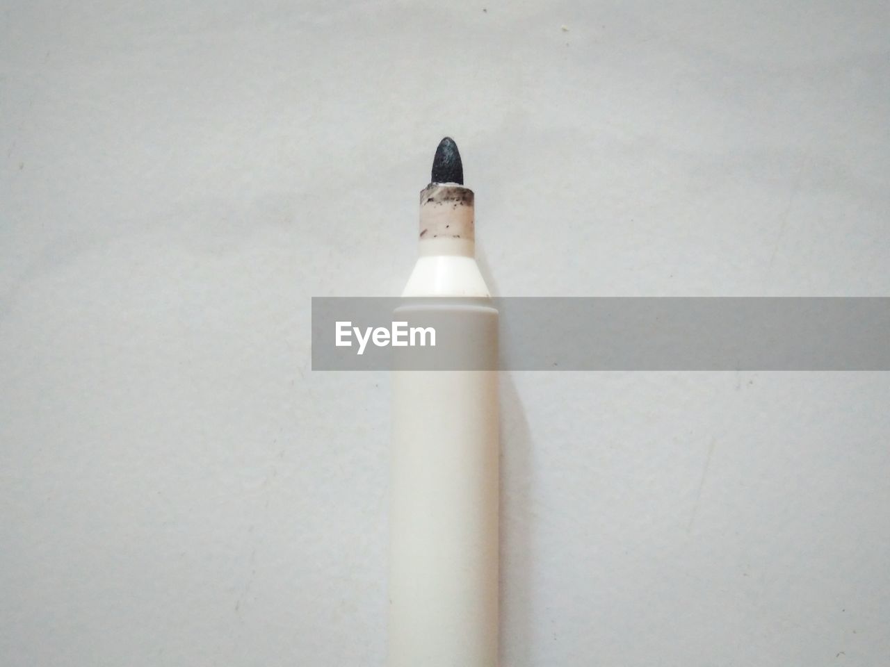 HIGH ANGLE VIEW OF PEN ON WHITE TABLE AGAINST WALL