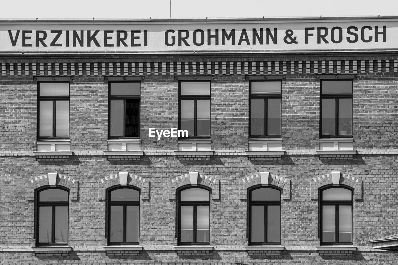 architecture, built structure, building exterior, black and white, window, no people, monochrome, text, history, monochrome photography, building, facade, day, western script, house, communication, city, outdoors