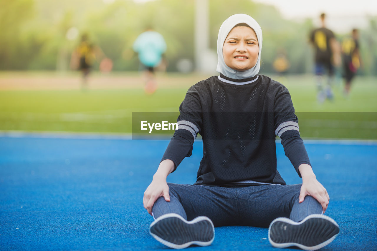 Portrait of female athlete sitting at stadium